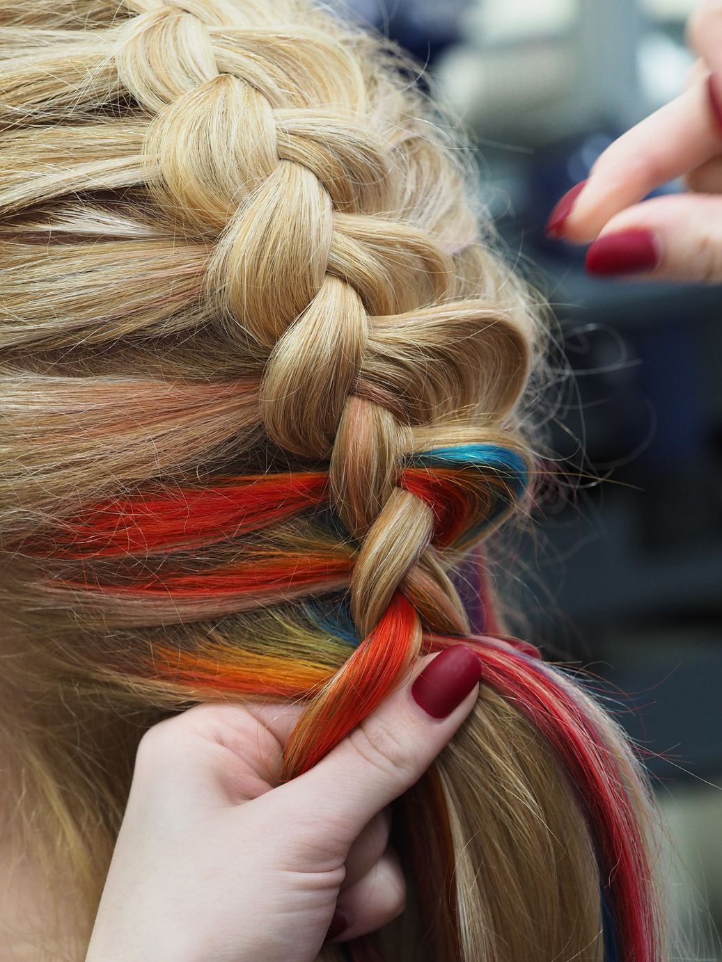 Rainbow hair in a braid. Braiding close up.